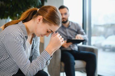 Genç bir kadın terapi seansında kendini sıkıntılı hissediyor. Psikologu akıl sağlığı için destek ve danışmanlık sağlıyor.