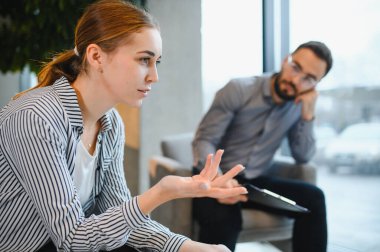 Bir kadın erkek psikologla açık açık konuşuyor, ruh sağlığı veya kişisel sorunları rahat bir ortamda tartışıyor.