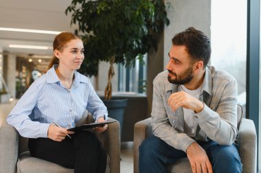 Terapi seansı sırasında kadın bir terapiste güvenen bir adam. Dinleyen, not yazan, destek öneren bir kadın.