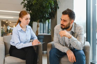 Erkek, kadın psikoloğuyla konuşur, duygularını paylaşır ve akıl sağlığı için profesyonel yardım ister.