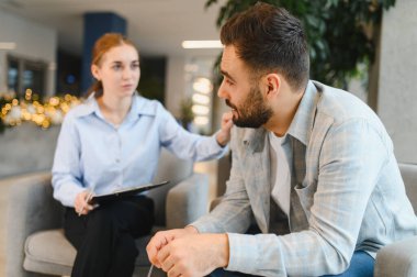 Bir psikologla konuşan, akıl sağlığı danışmanlığı sırasında empati ve yardım alan bir adam.