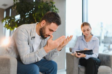 Erkek hasta danışmanla sorunları tartışıyor, ruhsal sağlık desteği ve profesyonel yardım istiyor