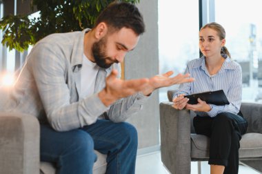 Erkek, kadın psikologla kişisel sorunları tartışıyor, profesyonel danışmanlık alıyor ve akıl sağlığı için destek alıyor.