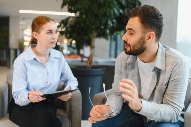 Erkek kadın psikoloğa güvenir, terapi seansında ruh sağlığı sorunlarını tartışır.