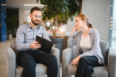 Psikolog, genç bir kadın hastayla danışmanlık seansı yapıyor. Rahat bir ortamda ruh sağlığı sorunlarını tartışıyor.