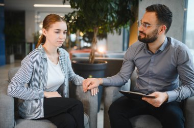 Genç bir kadın terapi seansı sırasında erkek psikologdan duygusal destek ve teselli almaktan rahatsız oluyor.