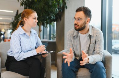 Hasta, profesyonel bir terapistle akıl sağlığı sorunları tartışıyor, modern bir ofis ortamında danışmanlık ve destek alıyor.