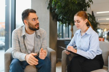 Erkek, kadın psikoloğuyla özel bir konuşma yapıyor. Ruh sağlığı ve duygusal destek için profesyonel danışmanlık alıyor.