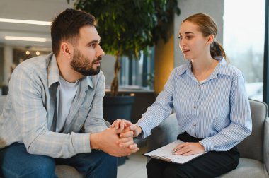 Ruh sağlığı için psikoterapi seansı sırasında erkek bir müşteriye duygusal destek ve danışmanlık sağlayan kadın psikolog