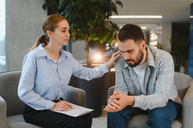 Psikolog, terapi sırasında depresyon ve stresten muzdarip bir adama empati ve destek sunuyor.