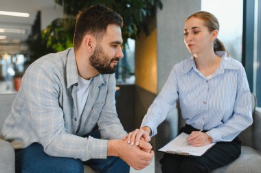 Psikolojik terapi seansında destek bulan bir adam, profesyonel bir danışmanla ruh sağlığı sorunlarını tartışıyor.