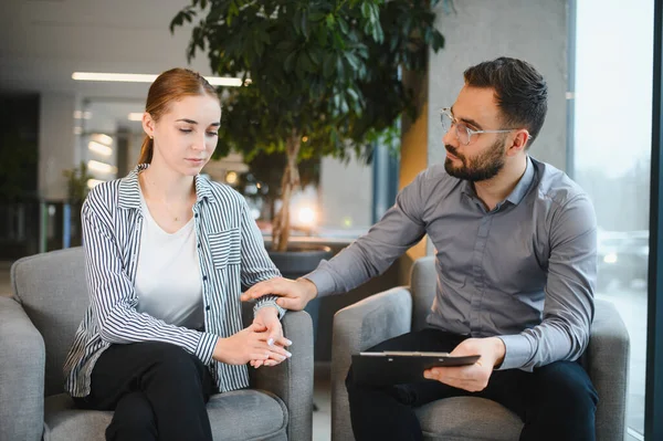 Terapi seansı sırasında genç bir kadın bir psikologla oturuyor. Stres ve akıl sağlığı sorunlarıyla uğraşan hastalara destek öneren adam