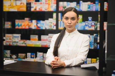 Tezgahta duran eczacı, çağdaş bir eczanede profesyonel hizmet ve sağlık tavsiyesi veriyor.