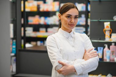 Eczanede gülümseyen beyaz üniformalı kendinden emin bir eczacı. Profesyonel tıbbi danışmanlık hizmeti sunuyor.