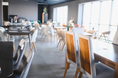 Mobilya mağazasının içinde çeşitli yeni yemek masaları, şık sandalyeler ve fiyat etiketleri, ev dekorasyonu ve alışveriş odaklı.