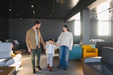 Aile el ele yürür, galeride mobilyalara bakar, yeni bir ev tasarımı ve mobilya tasarlar.