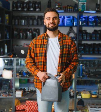 Bir otomotiv mağazasında elinde bir şişe motor yağı tutan bir müşteri. Araç bakımını ve onarımı temsil eder