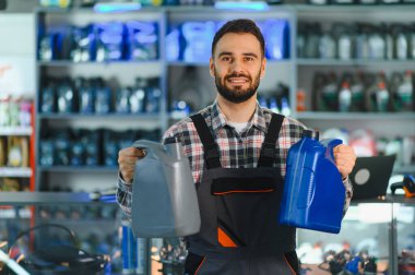 Gülümseyen tamirci araba bakımı ve hizmet için farklı motor yağı tipleri sunarak, en uygun araç performansını sağlar