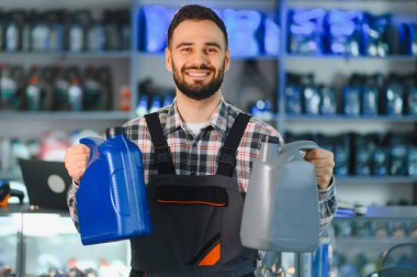 Gülümseyen tamirci farklı motor yağı ürünleri sunar, araba servisi ve motor bakımı için seçenekler sunar