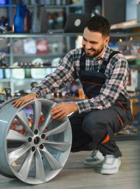 Otomobil teknisyeni yeni yeni bir araba var mı diye kontrol ediyor. Otomotiv tamirhanesinde çalışan bir adam. Perakende satış ve hizmet