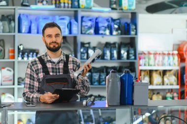 Otomotiv süspansiyon kolu tutan profesyonel bir tamirci, envanteri kontrol ediyor veya oto yedek parça dükkanında tamir emri hazırlıyor.