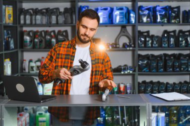 Satış elemanı araba parçaları seçer, bir araç için süspansiyon kontrol kolunu tutar, bir otomobil dükkanında bilgisayar kullanır.