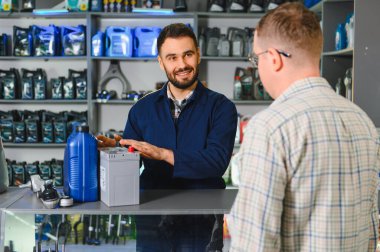 Araba parçaları ve aksesuarları olan bir perakende mağazasında müşteriye yardım etmek, ürünleri ve oto hizmet seçeneklerini açıklamak