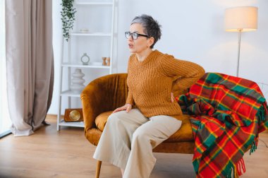 Sırtında ağır bir rahatsızlık hisseden bir kadın, bir evde bel ağrısı ve omurga yaralanması yaşıyor.