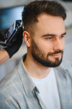 Trikoloğum, bir klinikte saç hastalığı teşhisi koymak için modern bir aletle hastanın kafa derisini inceliyor.