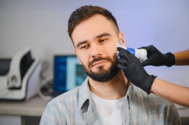 Dermatolojik sağlık ve tedavide uzmanlaşmış bir teşhis tarayıcısı olan modern bir adamın detaylı bir cilt analizi var.