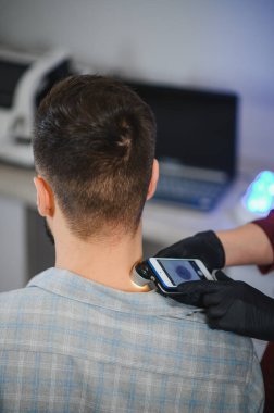 Dermatolog, özel bir akıllı telefon eklentisi kullanarak hastanın cildinde ben ve potansiyel cilt kanseri olup olmadığını araştırıyor.