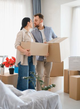 Mutlu çift taşınma gününü kutluyor, yeni evlerine karton kutular taşıyor, birlikte gelecek planları yapıyorlar.