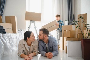 Mutlu aile kutuları açmaktan kaçınıyor, yeni dairelerinin zemininde birlikte vakit geçiriyorlar.