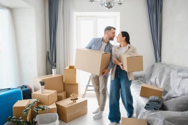 Karton kutular taşıyan genç bir çift yeni bir dairede yeni başlangıçları kutluyorlar. Yerleştirme ve ev sahipliği kavramı