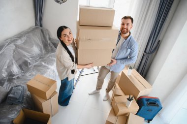 Karton kutular taşıyan mutlu çift, yeni evlerine taşınıyorlar ve birlikte yeni bir hayata başlıyorlar.