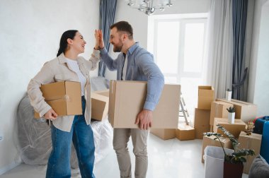 Mutlu çift beşlik çakıyor, karton kutular taşıyor ve yeni dairelerine taşınıp yeni bir sayfa açıyor.