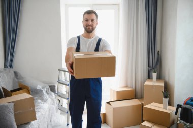 Boş daireye karton kutu getiren bir adam. Taşınma, teslimat ve konut değişikliği kavramı