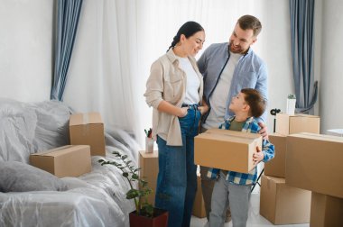 Mutlu bir aile yerleşiyor, anne ve baba oğullarının yeni evlerinde bir kutu taşımasını izliyor. Taşınma günü, taşınma konsepti