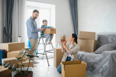 Aile yeni bir eve taşınıyor, mutlu duygularla dolu karton kutuları açıyor. Ev partisi sırasında ebeveynler ve çocuklar arasında bağ kurulması