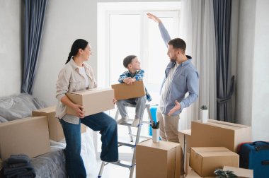 Mutlu bir aile yeni bir daireye ya da eve taşınıyor, depolama kutularından eşyaları açıyor, hayalleri canlandırıyor.