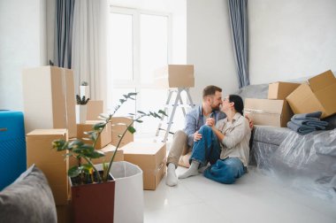 Bir çift yerde oturuyor, öpüşüyor ve kutluyorlar. Etrafı karton kutularla çevrili yeni bir daireye taşınıyorlar.