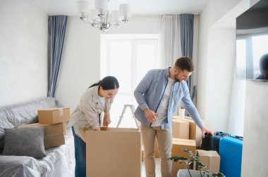 Mutlu çift yeni bir daireye ya da eve taşınıyor. Karton kutular ve kişisel eşyalarla çevrili. Yeni bir başlangıç yapıyorlar.