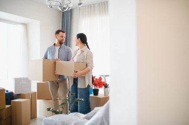 Karton kutular taşıyan mutlu çift, yeni bir eve ya da daireye taşınıyor. Yaşam tarzı taşınma ve ev sahipliği sahnesi