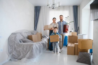 Mutlu bir aile yeni bir daireye giriyor, kutuları taşıyor, taşınmayı kutluyor ve kendi mülklerinde yeni bir başlangıç yapıyorlar.