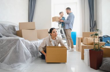 Aile, yeni bir dairede karton kutuları paketleyip açıyor, eşyaları yerleştiriyor ve taşınma sürecinin tadını çıkarıyor.