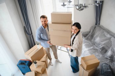 Genç, gülen bir çift karton kutular taşıyor, yeni evlerine ya da dairelerine taşınıyorlar, yeni bir başlangıcı kutluyorlar.