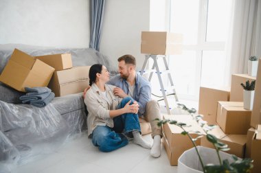 Yeni dairelerinde karton kutuları açmaya ara verip birbirlerine sarılıp bakıyorlar.