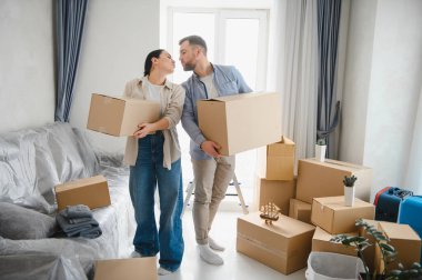 Karton kutular taşıyan genç bir çift yeni bir daireye yerleşmeye hazırlanıyor. Yeni yaşam alanı döşeniyor