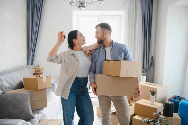 Mutlu çift kucaklaşıyor, ev anahtarlarını tutuyor, kutuları taşıyor, kendi dairelerinde yeni bir hayata başlıyorlar.