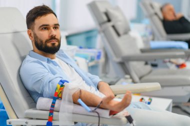 Modern bir klinikte kan bağışı için gönüllü olan bir adam sağlık hizmetlerine katkıda bulunuyor ve hayat kurtarıyor.